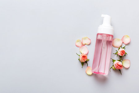 Fancy healthcare bottles for serum, micellar, tonic, toner, lotion, water and cream with rose flower. Natural oranic spa cosmetics concept. Mockup, template, top view.の写真素材