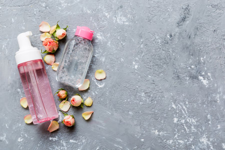 Fancy healthcare bottles for serum, micellar, tonic, toner, lotion, water and cream with rose flower. Natural organic spa cosmetics concept. Mockup, template, top view.の写真素材