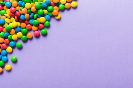 Mixed collection of colorful candy, on colored background. Flat lay, top view. frame of colorful chocolate coated candy.の写真素材