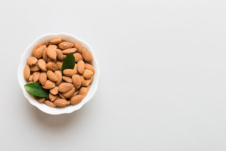 Fresh healthy Almond in bowl on colored table background. top view.の写真素材