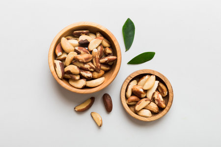 Fresh healthy Brazil nuts in bowl on colored table background. Top view Healthy eating bertholletia concept. super foods.の写真素材