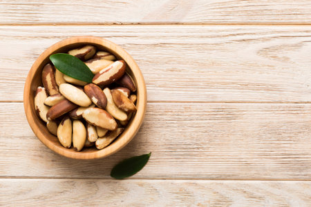 Fresh healthy Brazil nuts in bowl on colored table background. Top view Healthy eating bertholletia concept. super foods.の写真素材