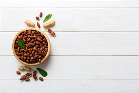 Fresh healthy peanuts in bowl on colored table background. Top view Healthy eating bertholletia concept. super foods.の写真素材