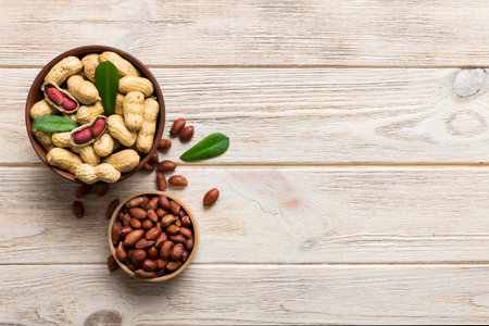Fresh healthy peanuts in bowl on colored table background. Top view Healthy eating bertholletia concept. super foods.の写真素材