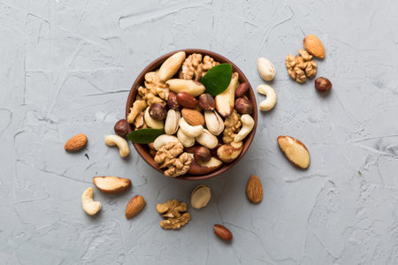 mixed nuts in bowl. Mix of various nuts on colored background. pistachios, cashews, walnuts, hazelnuts, peanuts and brazil nuts.の写真素材