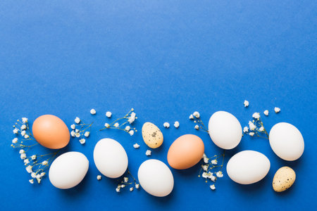 Happy Easter composition. Easter eggs on colored table with gypsophila. Natural dyed colorful eggs...