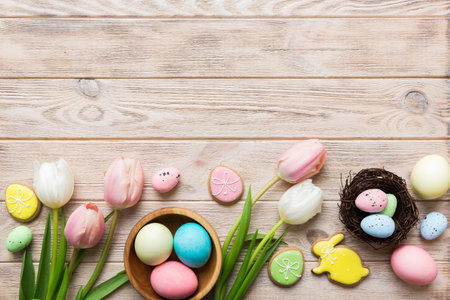 Easter frame with eggs, gift box and tulip on a colored background. The minimal concept. Top view...