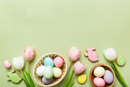 Easter frame with eggs, gift box and tulip on a colored background. The minimal concept. Top view Happy Easter composition. Card with a copy space of the place for the text.の写真素材