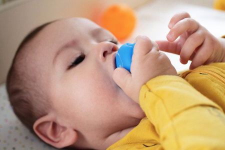 Cute adorable newborn baby playing with colorful rattle toy. baby with teether. six months old...