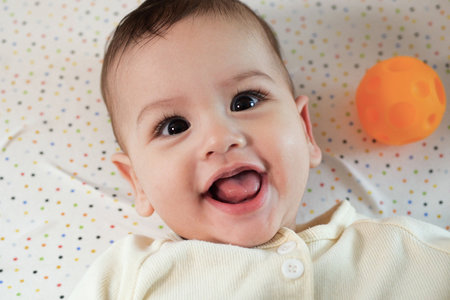 Happy newborn baby makes a funny face. Portrait of a crawling baby in his room close up.の写真素材