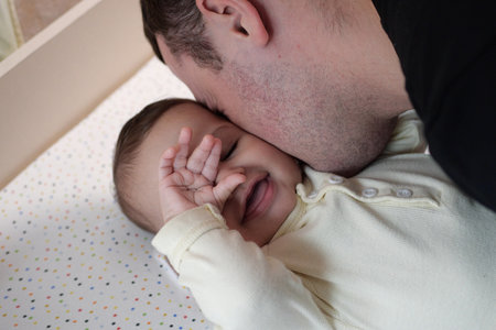 Happy dad and son having fun at home. Father and baby boy in the bedroom on a bright background....
