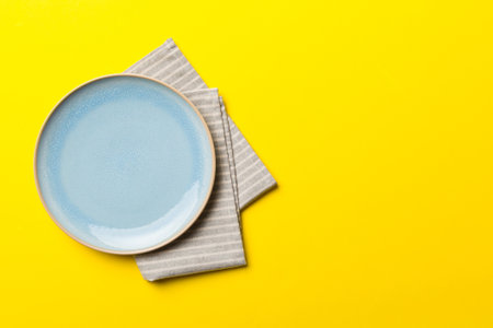 Top view on colored background empty round Blue plate on tablecloth for food. Empty dish on napkin with space for your design.の写真素材