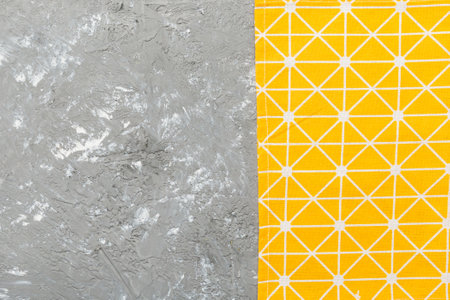 top view with yellow empty kitchen napkin isolated on table background. Folded cloth for mockup with...