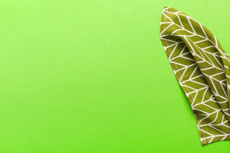 top view with green kitchen napkin isolated on table background. Folded cloth for mockup with copy space, Flat lay. minimal style.の写真素材