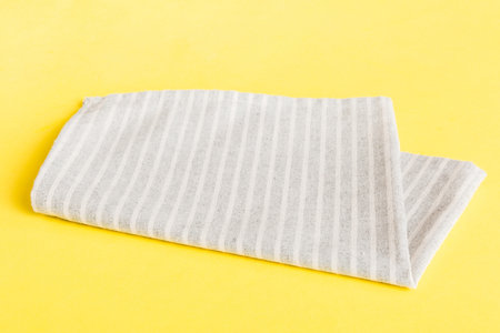 top view with gray kitchen napkin isolated on table background. Folded cloth for mockup with copy...