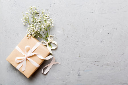 Gift or present box and flower gypsophila on light table top view. greeting card. Flat lay style with copy space.の写真素材