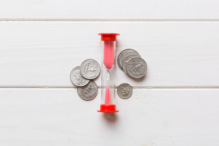 Deadline and time is money concept with hourglass and US coins currency. sand clock time saving concept.の写真素材