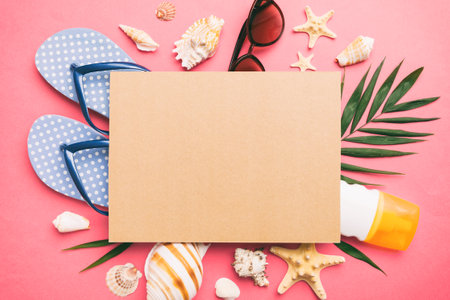 Summer time concept with blank greeting card and blank craft paper on colored background. Seashells from ocean shore in the shape of frame separated with space for text top view.の写真素材