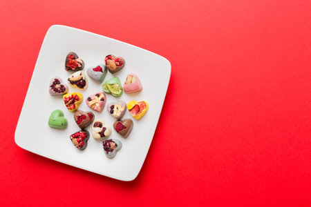 Plate with different chocolate on colored background. Assortment of fine chocolates top view vith copy space Health and obesity concept.の写真素材