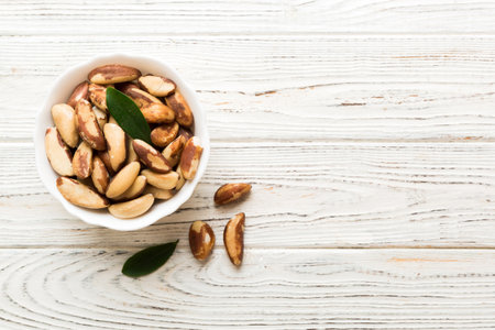 Fresh healthy Brazil nuts in bowl on colored table background. Top view Healthy eating bertholletia concept. super foods.の写真素材