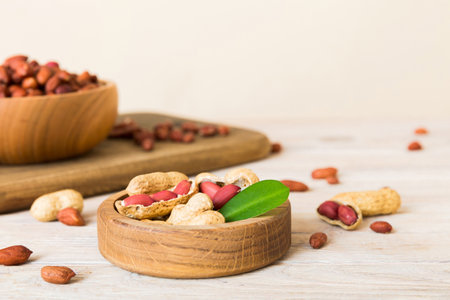 Fresh healthy peanuts in bowl on colored table background. Top view Healthy eating bertholletia...