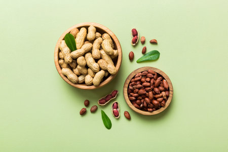 Fresh healthy peanuts in bowl on colored table background. Top view Healthy eating bertholletia...