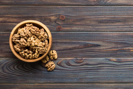 Fresh healthy walnuts in bowl on colored table background. Top view Healthy eating bertholletia...