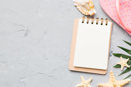 Blank writing book with summer beach accessories on background, copy space. Flat lay with copy space.の写真素材