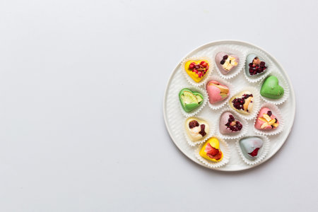 Plate with different chocolate on colored background. Assortment of fine chocolates top view vith copy space Health and obesity concept.の写真素材