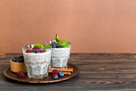 Healthy breakfast or morning with chia seeds vanilla pudding raspberry and blueberry berries on table background, vegetarian food, diet and health concept. Chia pudding with raspberry and blueberry.の写真素材