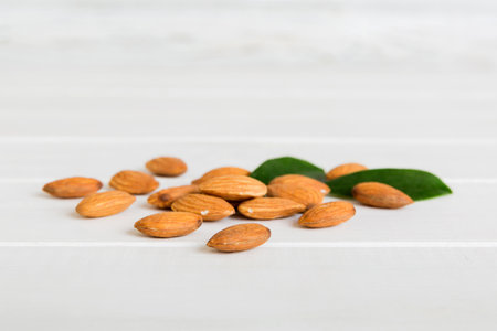 Close-up of Almond nuts with leaves on table background. top view. flat lay.の写真素材