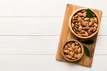 Fresh healthy Almond in bowl on colored table background. top view.の写真素材
