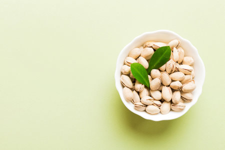 Fresh healthy Pistachios in bowl on colored table background. top view. Healthy eating concept. super foods.の写真素材