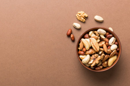 mixed nuts in bowl. Mix of various nuts on colored background. pistachios, cashews, walnuts, hazelnuts, peanuts and brazil nuts.の写真素材