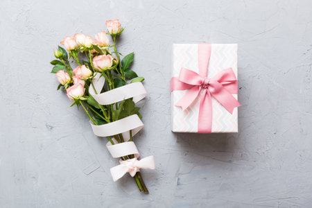design concept with pink rose flower and gift box on colored table background top view. Happy Holiday, Mother's day, birthday concept. Romantic flat lay composition.の写真素材