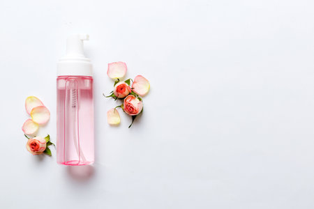 Fancy healthcare bottles for serum, micellar, tonic, toner, lotion, water and cream with rose flower. Natural oranic spa cosmetics concept. Mockup, template, top view.の写真素材