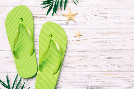 Flat lay composition with flip flops and seashell on colored background. Space for text view.