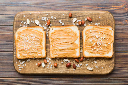 Peanut butter sandwiches or toasts on light table background.Breakfast. Vegetarian food. American...
