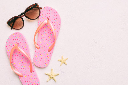 Summer travel concept. Flip flops, sunglasses and starfish on white. Top view on colored background.の写真素材