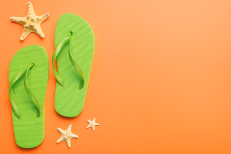 Flat lay composition with flip flops and seashell on colored background. Space for text view.の写真素材