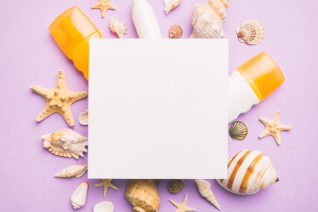 Summer time concept with blank greeting card and blank white paper on colored background. Seashells from ocean shore in the shape of frame separated with space for text top view.の写真素材