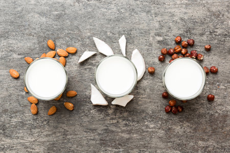 Set or collection of various vegan milk almond, coconut, cashew, on table background. Vegan plant based milk and ingredients, top view.の写真素材