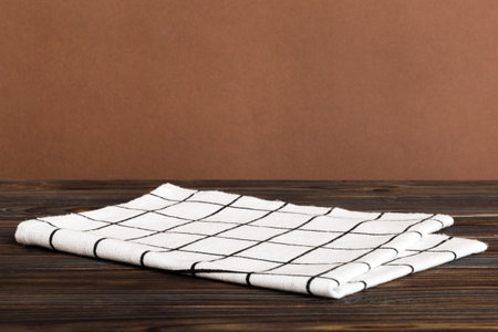 top view with white empty kitchen napkin isolated on table background. Folded cloth for mockup with...