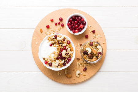 Healthy breakfast food with granola, yogurt, fruits and nuts. Dessert parfait with dried fruits for...