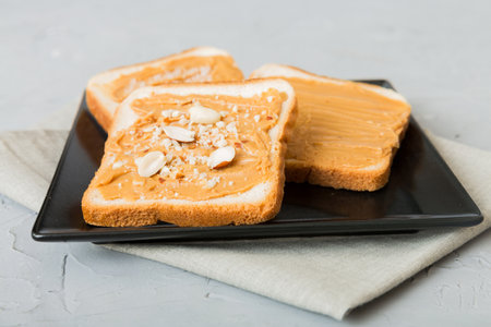Peanut butter sandwiches or toasts on light table background.Breakfast. Vegetarian food. American...
