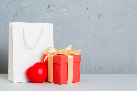 Shopping bag with gift box on colored background perspecrive view. Space for text holiday concept.の写真素材