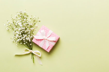Gift or present box and flower gypsophila on light table top view. greeting card. Flat lay style with copy space.の写真素材