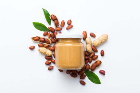 Bowl of peanut butter and peanuts on table background. top view with copyspace. Creamy peanut pasta in small bowl.の写真素材