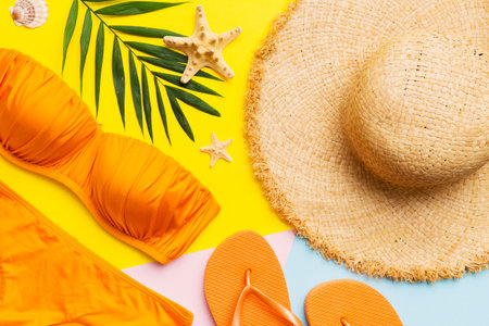 Woman swimwear and beach accessories flat lay top view on colored background Summer travel concept....