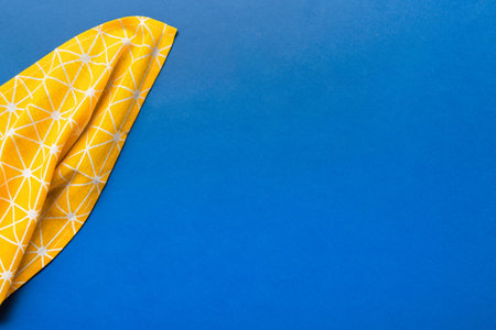 top view with yellow empty kitchen napkin isolated on table background. Folded cloth for mockup with copy space, Flat lay. minimal style.の写真素材